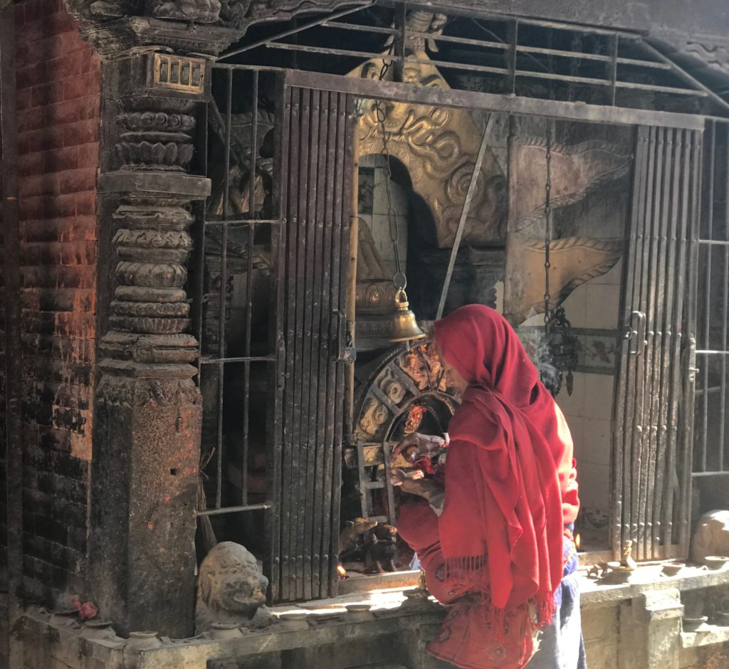 Woman praying before Shrine in Patan, Nepal